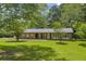 Classic brick single-story house with a cozy covered porch and an expansive green lawn at 676 Smith Store Rd, Covington, GA 30016