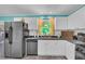 Well-lit kitchen features white cabinets, stainless steel appliances, subway tile backsplash, and granite countertops at 676 Smith Store Rd, Covington, GA 30016