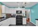 Bright kitchen boasts white cabinets, modern appliances, and a view into the pantry for easy access to supplies at 676 Smith Store Rd, Covington, GA 30016