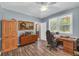 Comfortable office area with ample natural light, laminate flooring, and classic wood furniture at 676 Smith Store Rd, Covington, GA 30016