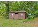 Exterior of shed on the property with some overgrown vegetation around it at 676 Smith Store Rd, Covington, GA 30016