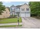 Two-story home with a well-kept lawn, double garage, and charming architectural details at 7530 Springbox Dr, Fairburn, GA 30213