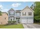 Charming two-story home with a two-car garage, well-maintained lawn, and inviting curb appeal at 7530 Springbox Dr, Fairburn, GA 30213
