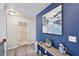 Upstairs hallway with a decorative blue wall, hardwood floors, and a doorway to a bathroom at 7530 Springbox Dr, Fairburn, GA 30213