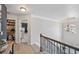 Hallway with hardwood floors, elegant lighting fixtures, and a view of the stairway at 7530 Springbox Dr, Fairburn, GA 30213
