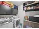 Laundry room featuring a modern washer and dryer, storage cabinets, and shelving units at 7530 Springbox Dr, Fairburn, GA 30213