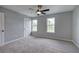 Bedroom features neutral walls, carpet, a ceiling fan, and two windows at 128 Evergreen Trl # 4, Cartersville, GA 30121