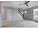 Spacious living room with gray floors, modern ceiling fan, stairs, and a bright, inviting atmosphere at 128 Evergreen Trl # 4, Cartersville, GA 30121