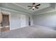 A gray painted main bedroom featuring a ceiling fan, and access to a powder room at 128 Evergreen Trl # 4, Cartersville, GA 30121