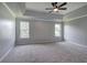 This main bedroom features tray ceilings, fresh gray paint, a ceiling fan, and two windows at 128 Evergreen Trl # 4, Cartersville, GA 30121