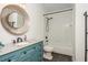Well-lit bathroom with turquoise vanity, modern fixtures, and bathtub shower at 165 Ansley Way, Roswell, GA 30075