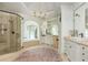 This bathroom features a glass shower, tub, and white cabinets at 165 Ansley Way, Roswell, GA 30075