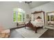 Elegant bedroom features a four-poster bed, large window, and hardwood floors at 165 Ansley Way, Roswell, GA 30075