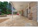 Expansive covered patio with stone flooring, outdoor fireplace, and views of the landscaped backyard at 165 Ansley Way, Roswell, GA 30075