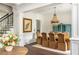 Open-concept dining room with a stylish chandelier, hardwood floors, and classic white trim at 165 Ansley Way, Roswell, GA 30075