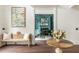 Inviting entry with hardwood floors, decorative bench, and arched doorway into a stylish music room at 165 Ansley Way, Roswell, GA 30075