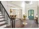 Elegant foyer with high ceilings, wrought iron staircase, and a stunning chandelier, with the front door in view at 165 Ansley Way, Roswell, GA 30075