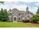 Beautiful stone home featuring a turret, symmetrical facade, arched windows, and manicured lawn at 165 Ansley Way, Roswell, GA 30075