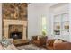 Cozy living room with stone fireplace, hardwood floors, and built-in shelving at 165 Ansley Way, Roswell, GA 30075
