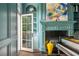 Bright music room showcases a fireplace, custom shelving, grand piano, and French door at 165 Ansley Way, Roswell, GA 30075