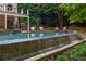 A stunning pool with a beautiful waterfall feature and plenty of seating for relaxation at 165 Ansley Way, Roswell, GA 30075