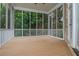 Relaxing screened porch with wood-look flooring, white railings, and private wooded views at 165 Ansley Way, Roswell, GA 30075