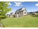 Lush backyard offers a serene setting with plenty of green space, mature trees, and a view of the home's exterior at 2545 Bertrand Way, Cumming, GA 30041