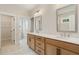 Dual sink bathroom featuring stylish wood cabinets and white countertop and a walk-in closet at 2545 Bertrand Way, Cumming, GA 30041