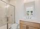 Modern bathroom features a walk-in shower with glass door and a wooden vanity with white countertop at 2545 Bertrand Way, Cumming, GA 30041