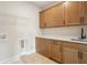 Practical laundry room with ample cabinet space, countertop, and sink for convenient chores at 2545 Bertrand Way, Cumming, GA 30041