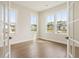 Bright, empty home office with large windows, white trim and dark hardwood floors at 2545 Bertrand Way, Cumming, GA 30041