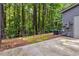 Backyard with concrete patio overlooking a small wooded area at 3335 Thornbridge Dr, Powder Springs, GA 30127