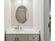 Powder room boasts white vanity, oval mirror and updated fixtures at 3335 Thornbridge Dr, Powder Springs, GA 30127
