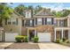 Two-story brick and vinyl townhome with a one-car garage, black shutters, and manicured landscaping at 3335 Thornbridge Dr, Powder Springs, GA 30127