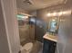 Updated bathroom featuring a glass-enclosed shower with decorative tile and modern vanity at 5090 Lorraine Pl, Forest Park, GA 30297