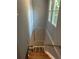A stairwell with hardwood steps and painted walls, featuring a window at the top landing for natural light at 5090 Lorraine Pl, Forest Park, GA 30297