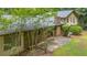 View of a house with brick and wood exterior, patio, and a yard with scattered trees at 5632 Stillwater Ct, Stone Mountain, GA 30087