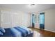 Bright bedroom featuring hardwood floors, a blue striped bedspread, and natural light from the window at 5632 Stillwater Ct, Stone Mountain, GA 30087