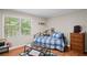 Bedroom with hardwood floors features a large window, comfortable bed, and ample natural light at 5632 Stillwater Ct, Stone Mountain, GA 30087