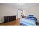 Bedroom with hardwood floors, a blue striped bedspread, and a dark wood dresser at 5632 Stillwater Ct, Stone Mountain, GA 30087