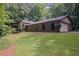 Charming brick home with arched windows, lush lawn, and surrounded by mature trees at 5632 Stillwater Ct, Stone Mountain, GA 30087