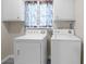 Functional laundry room with white washer and dryer and cabinets, offering a practical space at 5632 Stillwater Ct, Stone Mountain, GA 30087
