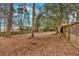 Overgrown fenced backyard with scattered piles of leaves and mulch at 1222 E Forrest Ave, Atlanta, GA 30344