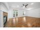Open living room with hardwood flooring, fireplace, ceiling fan, and access to a balcony at 238 Balsam Dr, Canton, GA 30114