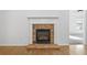 Cozy fireplace in a living room with hardwood floors and natural light from a window in the background at 238 Balsam Dr, Canton, GA 30114