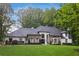 Stunning stone and white two-story home with meticulously maintained lawn and lush landscaping at 1460 Lakemist Ct, Roswell, GA 30075
