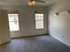 Cozy bedroom featuring neutral carpet, two windows, and a classic paneled door at 2612 Peterboro Row, Marietta, GA 30062