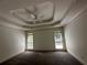 Spacious bedroom featuring a tray ceiling, neutral paint, and two bright windows with natural light at 2612 Peterboro Row, Marietta, GA 30062