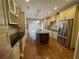 Eat-in kitchen featuring stainless appliances, custom cabinets, wood floors, and an island with a sink at 2612 Peterboro Row, Marietta, GA 30062