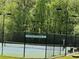 View of neighborhood tennis court with green and blue surface, benches, and well lit for evening play at 2612 Peterboro Row, Marietta, GA 30062